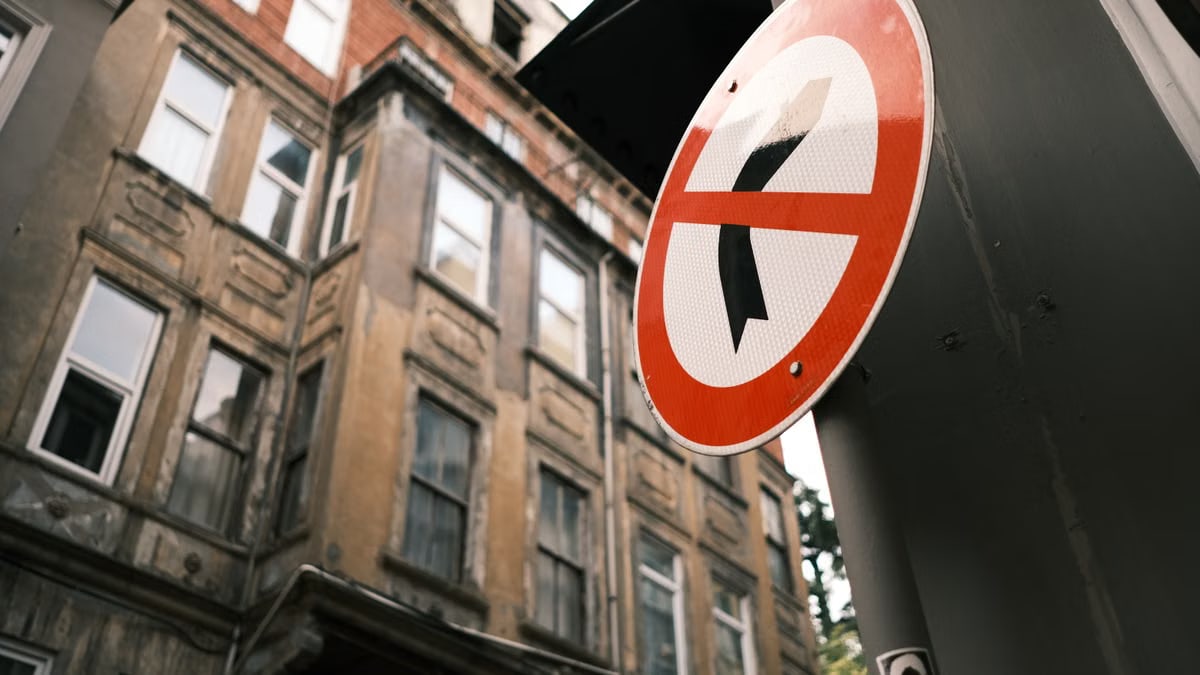 Close-up of a 'No Right Turn' sign with a historic building in the background, captured from a low angle.